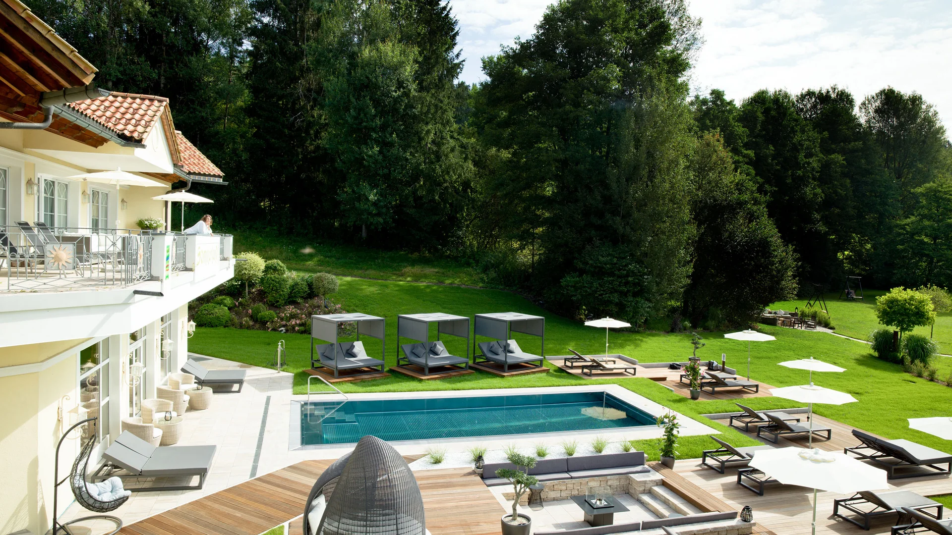 Moderner Garten mit Pool, Liegestühlen und grüner Landschaft