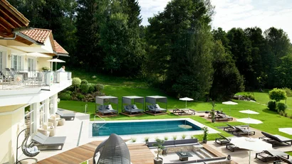 Moderner Garten mit Pool, Liegestühlen und grüner Landschaft