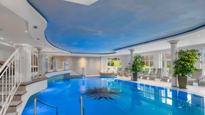 Innenpool mit blauem Himmel-Decke und Liegestühlen am Rand